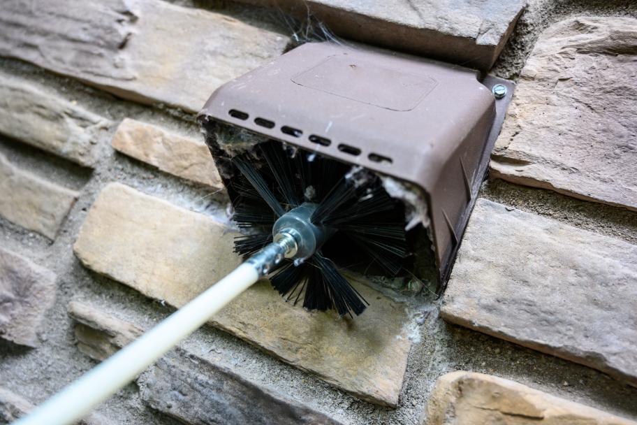 nettoyage avec une brosse d'un tuyau de sécheuse ventilation à l'extérieur d'un logement avec Océanick Nettoyage au Québec