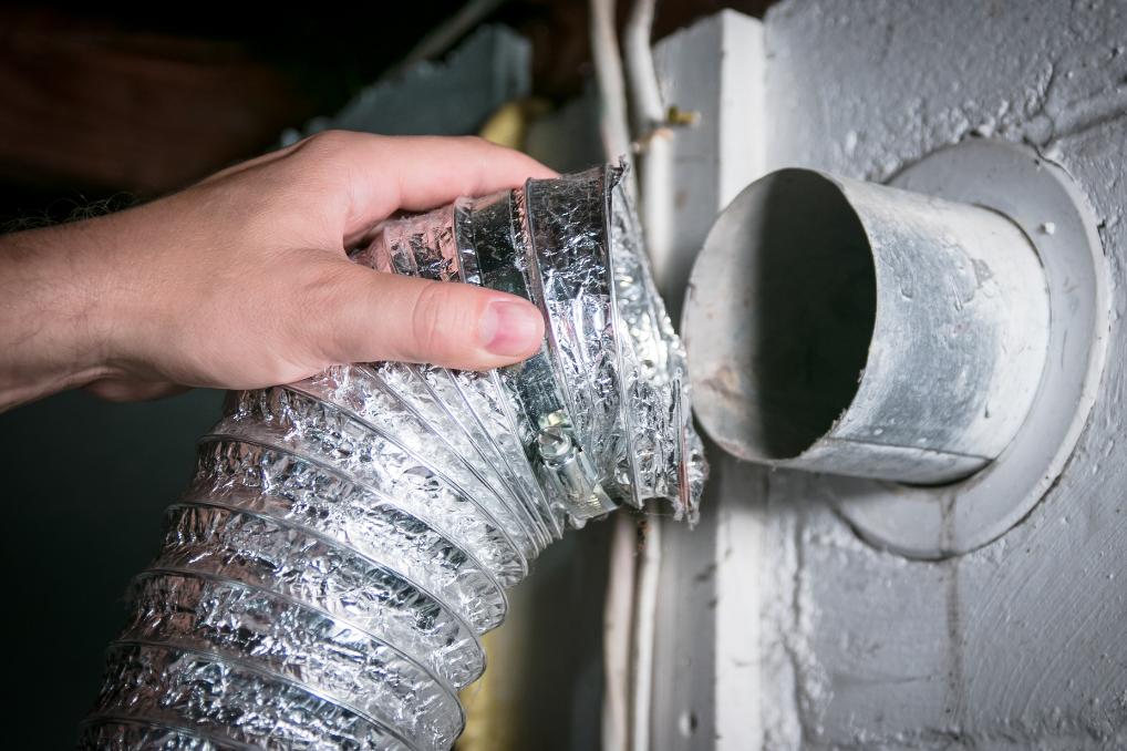 professionnel inspectnt l'intérieur d'un tuyau de sécheuse pour voir l'état. Océanick Nettoyage au Québec Canada