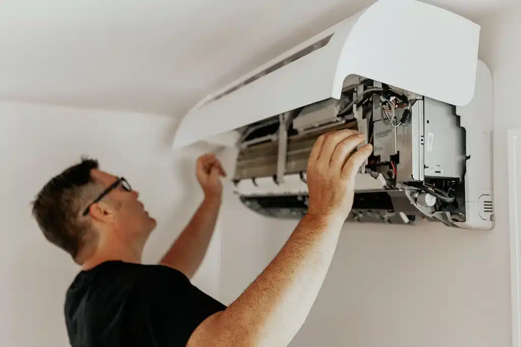 Technicien HVAC effectuant l’entretien d’un climatiseur mural