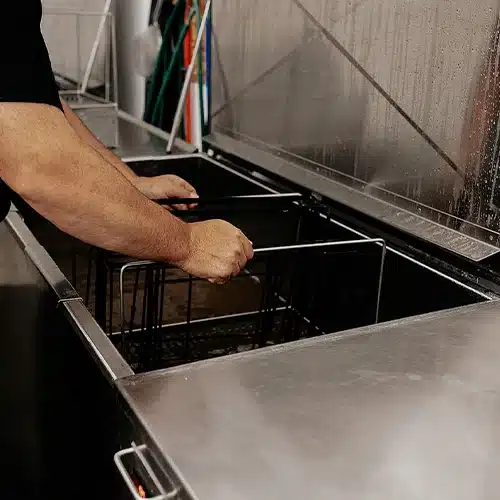 Technicien nettoyant une hotte de cuisine commerciale