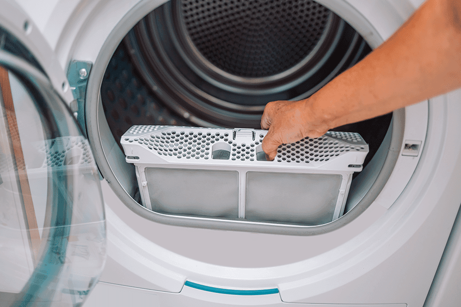 Technicien nettoyant le filtre d’une laveuse industrielle