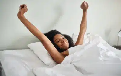 Femme s’étirant au réveil — sommeil réparateur dans une maison saine