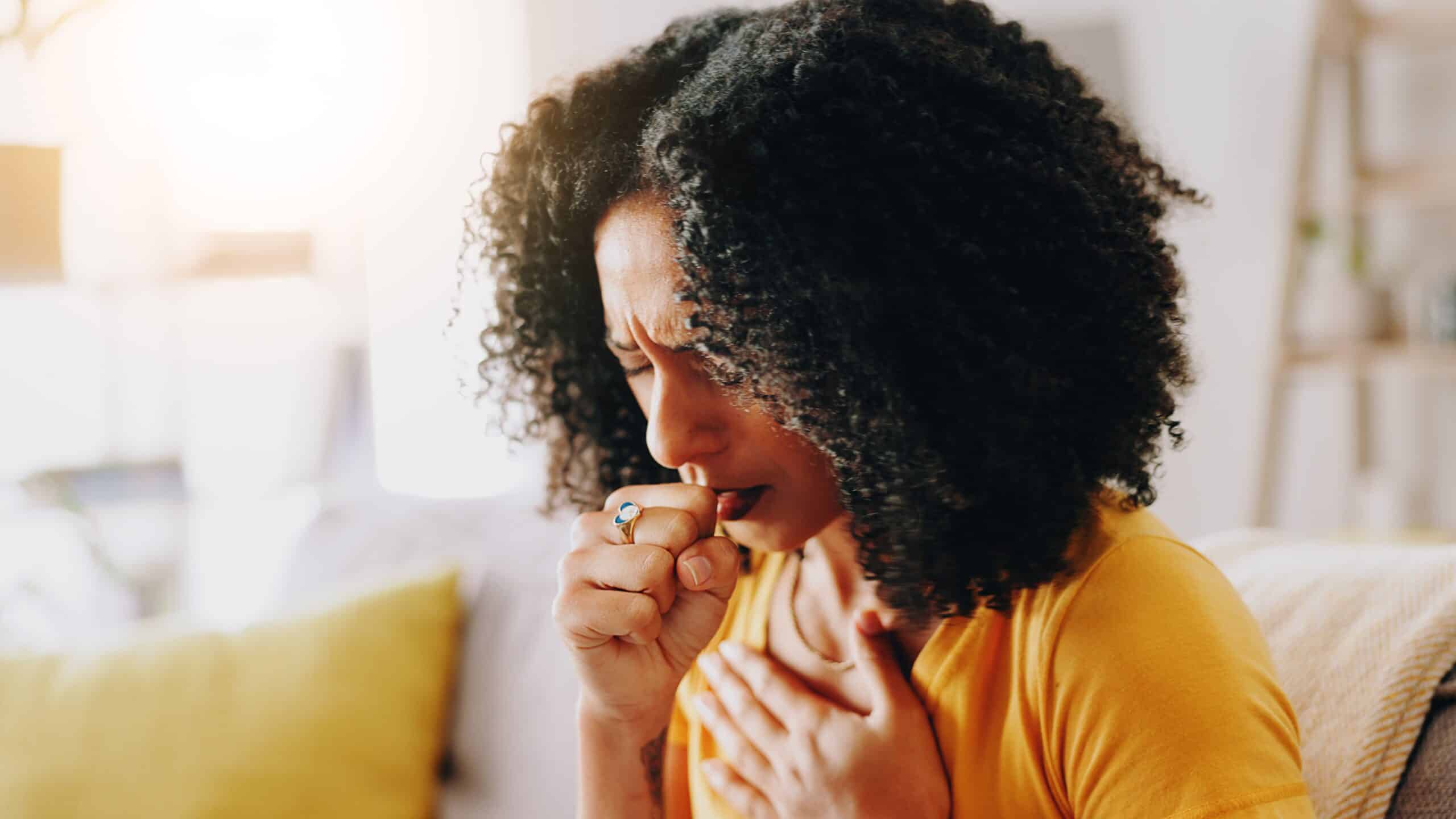 Femme toussant à la maison — qualité de l’air intérieur et allergènes